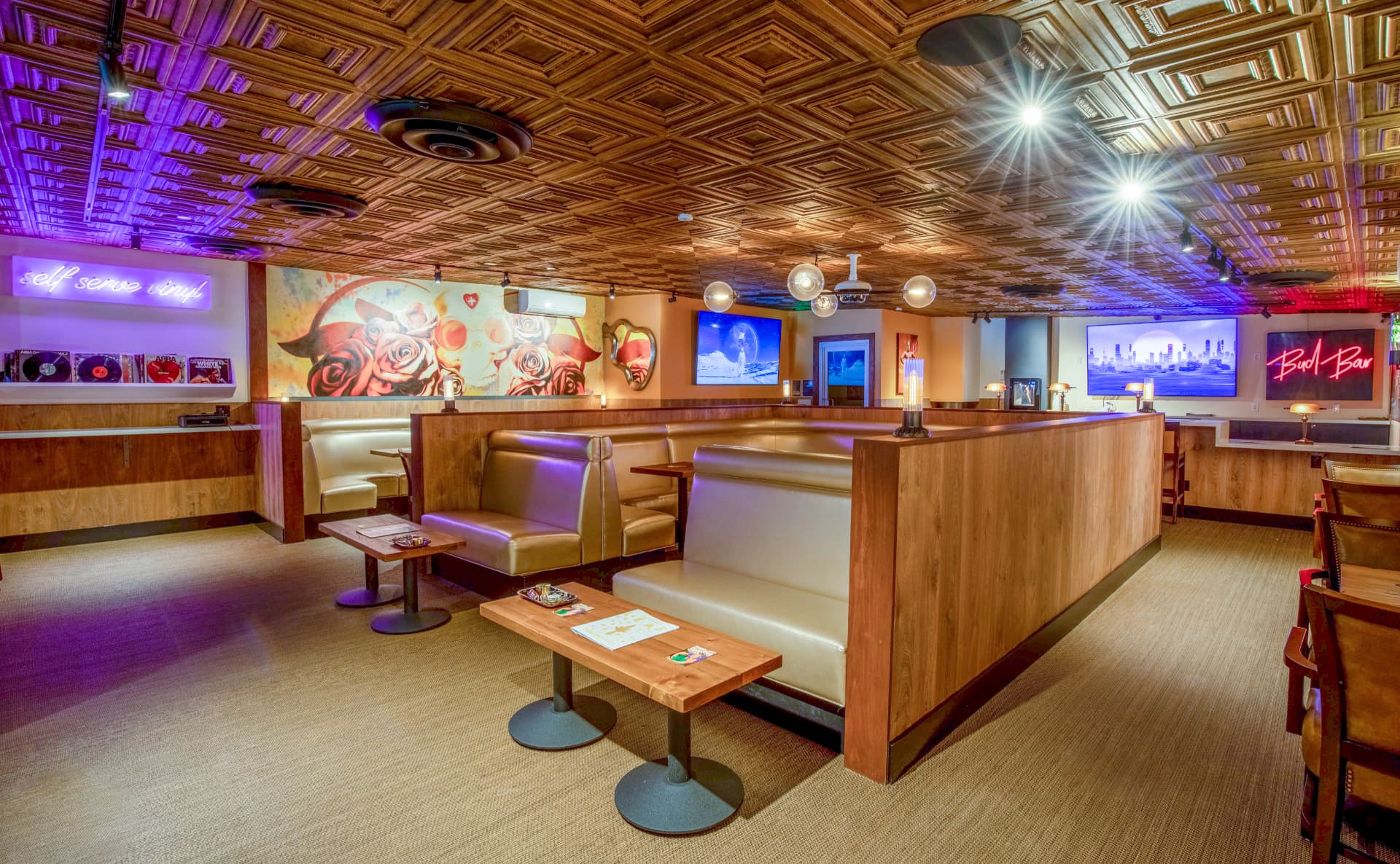 The lounge at Mission Cannabis Club with vinyl wall, murals and city-view screens
